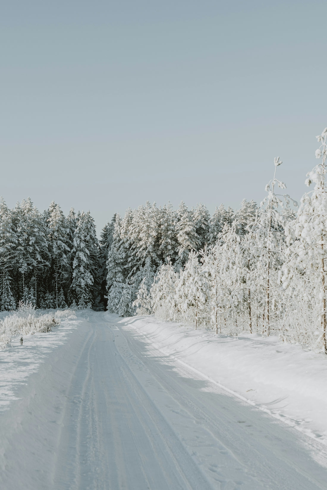 a person riding skis down a snow covered road
