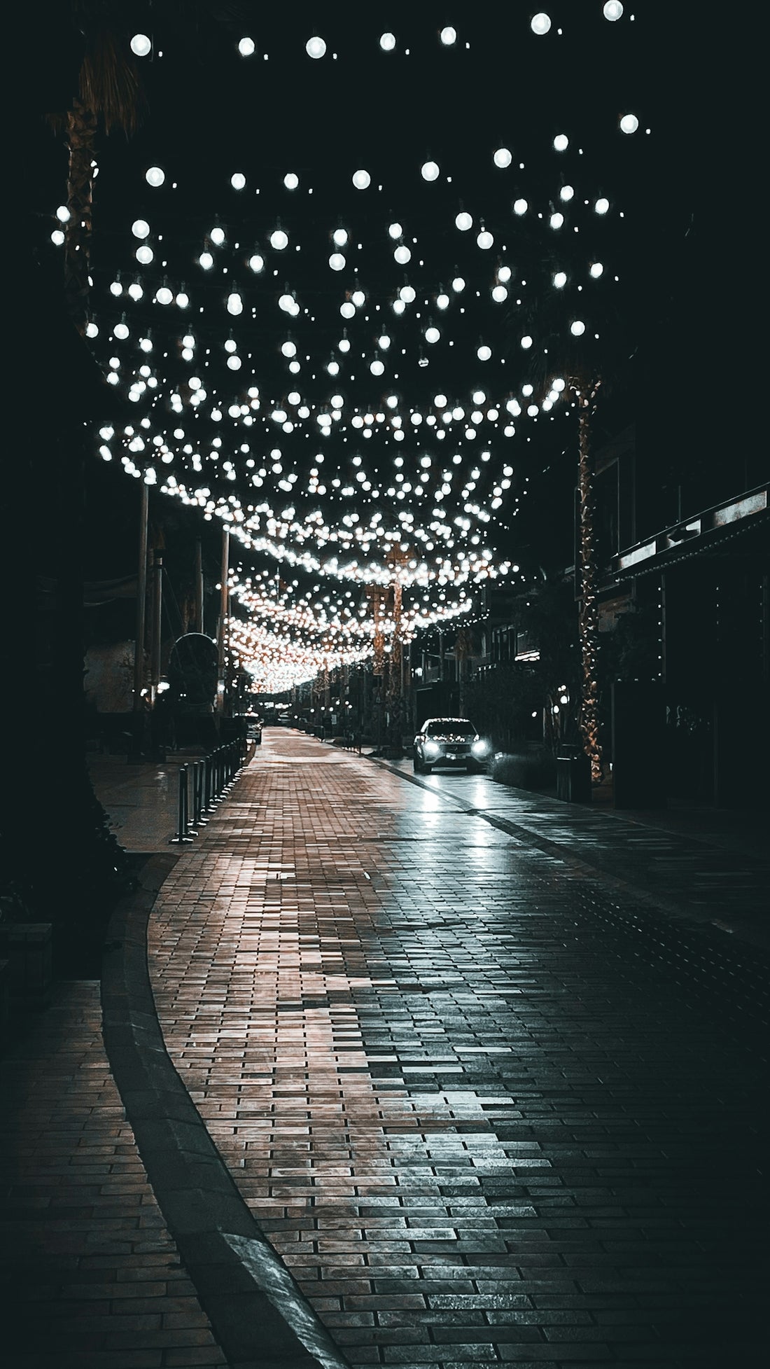 a city street with lights hanging from the ceiling